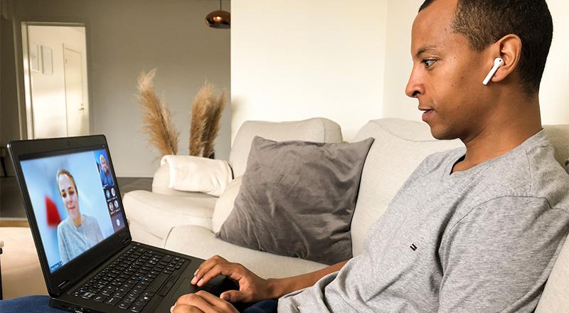 Man working remotely with a laptop on his lap.
